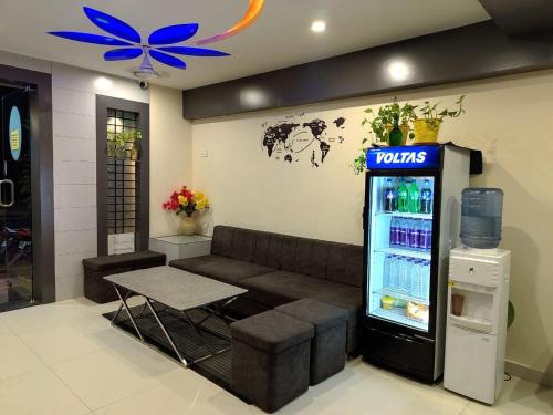 a tots vending machine in a room with a couch at Hotel Amigo in Ratlām