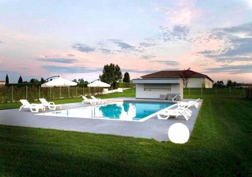 a swimming pool with chairs and a house at Country House Campofiore in Pontelongo