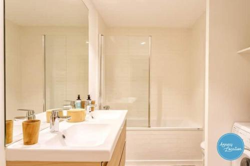 une salle de bain blanche avec un lavabo et une douche dans l'établissement Duplex les Glycines, à Écharvine