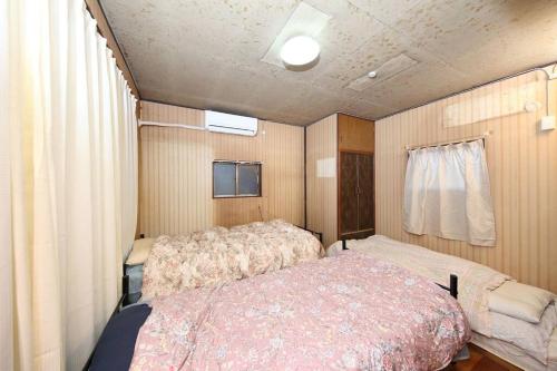 - une chambre avec un lit dans une caravane dans l'établissement ドミトリー月の光莉, à Tokyo