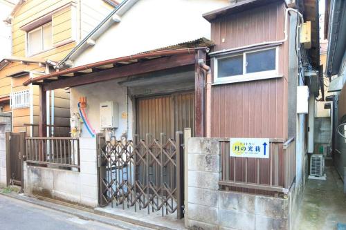 une petite maison avec un portail et une porte dans l'établissement ドミトリー月の光莉, à Tokyo