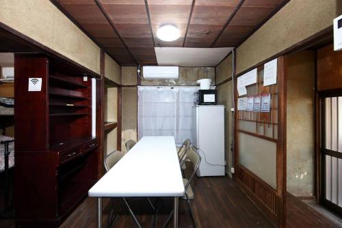- une cuisine avec une table et des chaises blanches dans la chambre dans l'établissement ドミトリー月の光莉, à Tokyo
