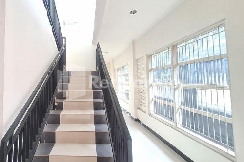 a staircase in a building with large windows at De Peppzzz near UGM Yogyakarta RedPartner in Kejayan