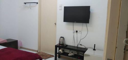 a room with a television and a phone on a table at BaniS Homestay in Shah Alam