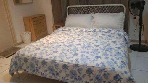 a bed with a blue and white blanket on it at BaniS Homestay in Shah Alam