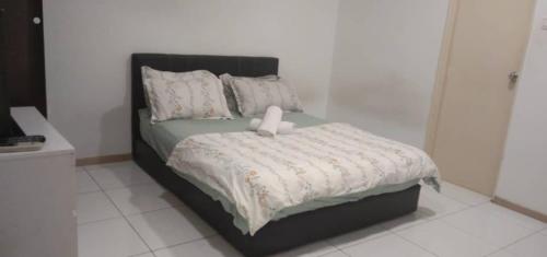 1 cama con cabecero negro y sábanas y almohadas blancas en BaniS Homestay, en Shah Alam