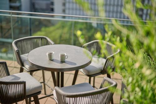 a table and chairs with two cups on it on a balcony at The Royal Park Hotel Iconic Nagoya in Nagoya
