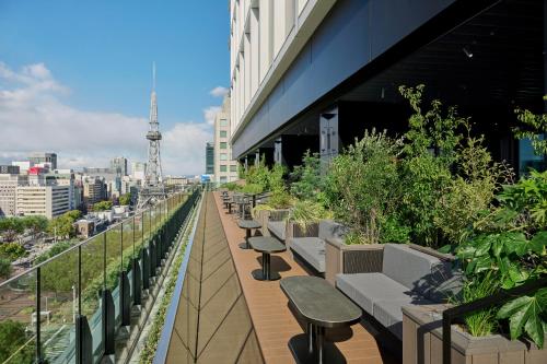 a balcony with tables and benches on a building at The Royal Park Hotel Iconic Nagoya in Nagoya
