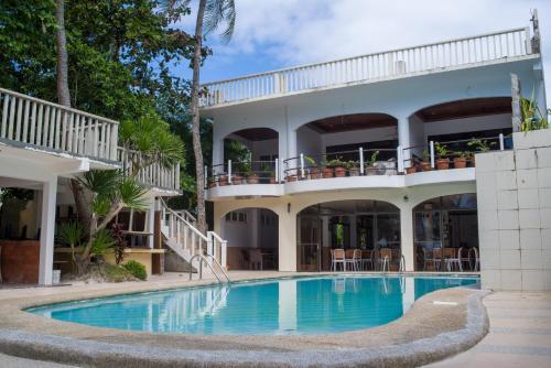 a large house with a swimming pool in front of it at Lukay Las Brisas in Boracay