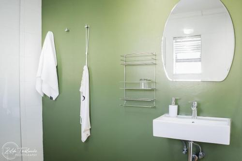 a bathroom with a white sink and a mirror at Perfek Stay Guesthouse in Secunda