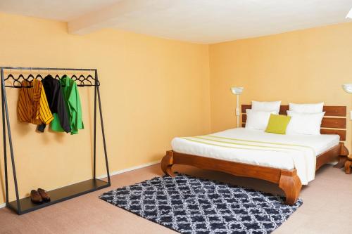 a bedroom with a bed and a rack of clothes at Appartement T2 avec ascenseur privé in Antananarivo
