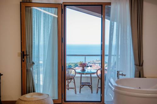 a bathroom with a tub and a view of the ocean at VillaQua Boutique Hotel in Sile