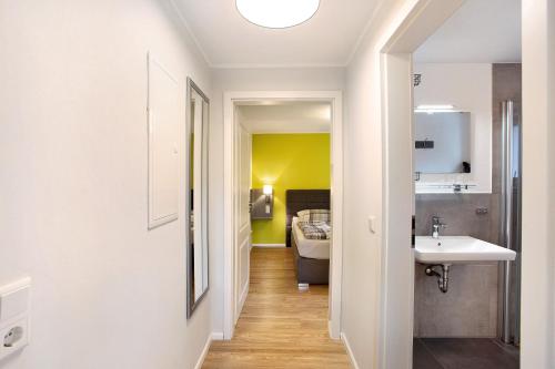 een badkamer met een wastafel en een bed in een kamer bij Ferienwohnung im Eichholz in Arnsberg