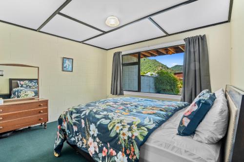 een slaapkamer met een bed en een raam bij Coastal Charm - Picton Holiday Home in Picton