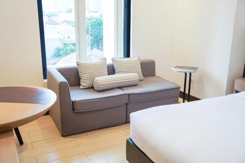 a living room with a couch and a window at Lemansion Senopati in Jakarta