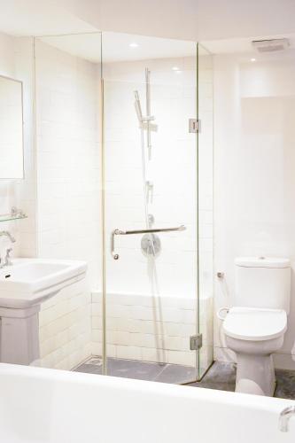a bathroom with a shower and a toilet and a sink at Lemansion Senopati in Jakarta