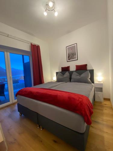 ein Schlafzimmer mit einem großen Bett mit einer roten Decke in der Unterkunft CityLake G23 Apartments mit kostenlosem Parkgaragen-Stellplatz !! in Gmunden