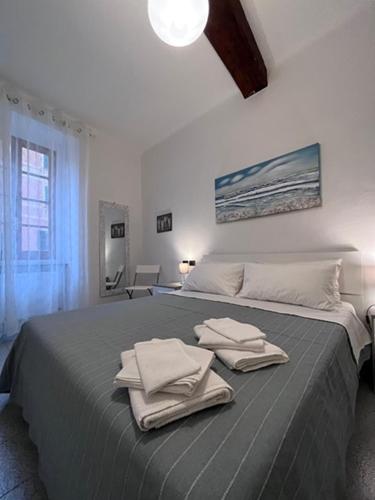 Un dormitorio con una cama grande con toallas. en LaMarina, en Camogli