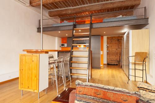 un lit mezzanine dans une pièce avec une cuisine et un bar dans l'établissement Les Mats du port - appt climatisé, à Marseille