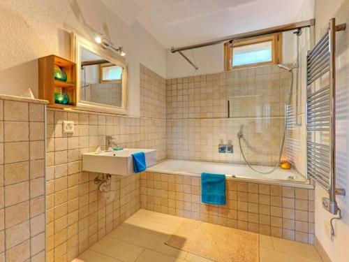 a bathroom with a tub and a sink and a shower at Chalet Bryher in Les Collons