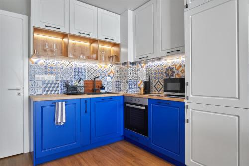 a blue and white kitchen with white cabinets at The Swing in Burgas City
