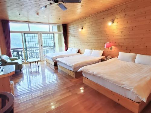a hotel room with two beds and a balcony at Kingtaiwan Hotel in Lugu Lake