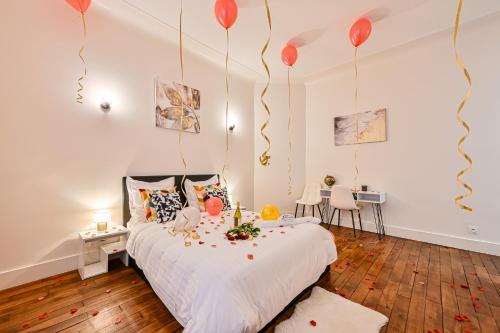 Magnifique Appartement de luxe & familial avec Parking - Paris 16 في باريس: غرفة نوم مع بالونات حمراء معلقة من السقف