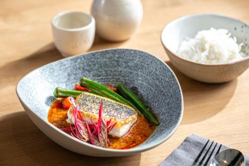 a bowl of food with meat and vegetables on a table at Lloyd's Inn Kuala Lumpur in Kuala Lumpur