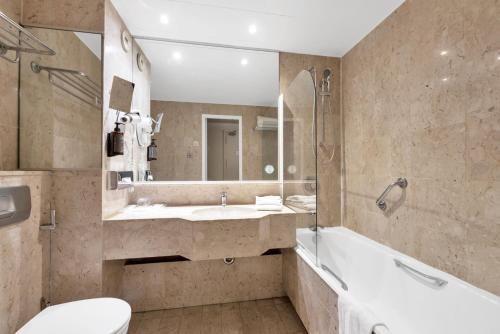 a bathroom with a tub and a sink and a toilet at Hotel Beau Rivage in Nice