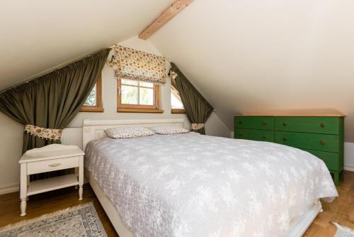 1 dormitorio con 1 cama blanca y armarios verdes en Family apartament, en Pervalka
