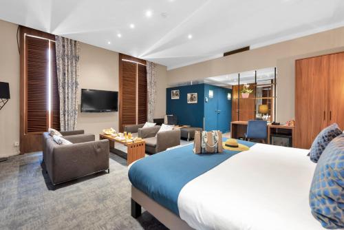 a hotel room with a bed and a living room at Hotel Beau Rivage in Nice