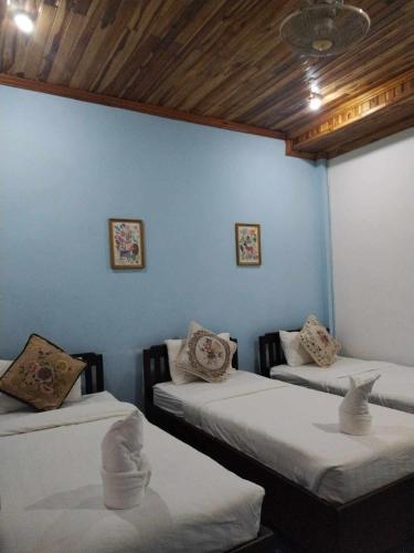 Zimmer mit 3 Betten und blauer Wand in der Unterkunft Phanh Tha Sone House in Luang Prabang