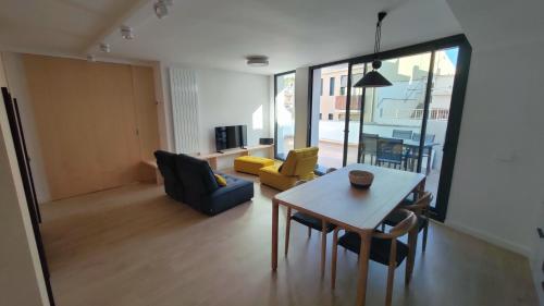 een woonkamer met een tafel en gele stoelen bij Rutlla 10 in Girona