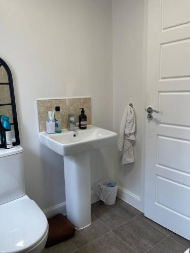 y baño con lavabo blanco y aseo. en MODERN AND IMMACULATE PRIVATE ROOM IN NUNEATON, en Caldecote