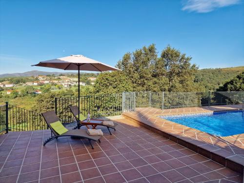 a patio with two chairs and an umbrella next to a pool at Casa Del Ingles - Luxury Private Village & Pool in Rural Valley in Pontevedra