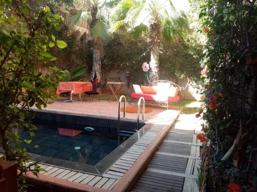 a swimming pool in a backyard with a table and chairs at Janna d'Ifni in Sidi Ifni