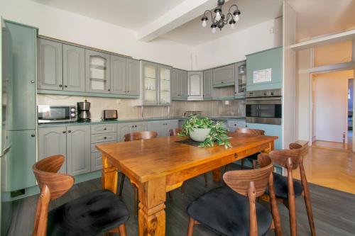 a kitchen with a wooden table and chairs at Huge apartments Smoleńsk street in Krakow