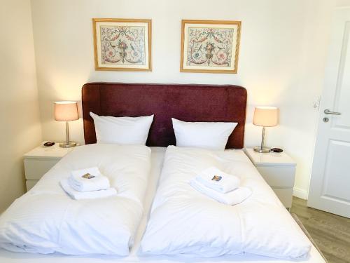 Una cama con dos toallas blancas encima. en Luxus Ferienwohnung Bergblick, en Goslar