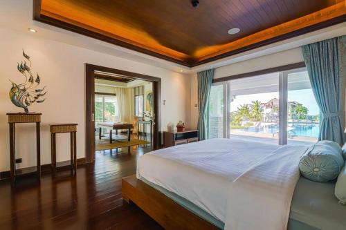 ein Schlafzimmer mit einem großen Bett und einem großen Fenster in der Unterkunft 7 Bedrooms Mansion on The Golf Course! JB2 in Hua Hin
