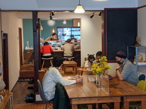 a group of people sitting around a wooden table at Guesthouse Tomaru in Takayama