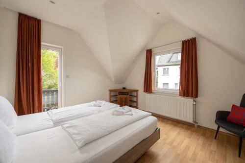 a bedroom with a large white bed and a window at Villa Ennert in Winterberg
