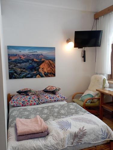 2 camas en una habitación con TV en la pared en A3Apartament 2 pokojowy aneks kuchenny 2 łazienki wspólne z gośćmi willa skoczek pobyt na termach dla 2 osób gratis en Zakopane