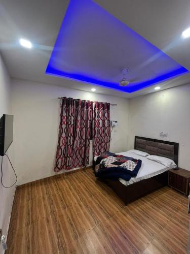 een kamer met een bed en een blauw plafond bij SHRI GANPATI GUEST HOUSE in Amritsar