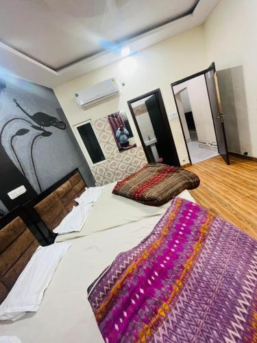 a bedroom with a large bed with a rug on it at SHRI GANPATI GUEST HOUSE in Amritsar