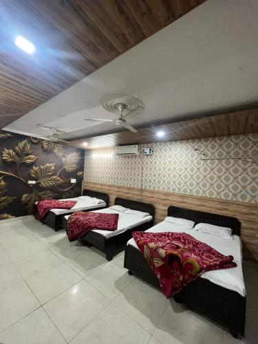 阿姆利則的住宿－SHRI GANPATI GUEST HOUSE，带三张床和天花板的客房