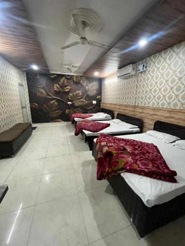quatro camas alinhadas em fila num quarto em SHRI GANPATI GUEST HOUSE em Amritsar