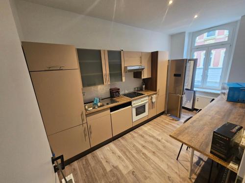 eine leere Küche mit einem Kühlschrank und einem Tisch in der Unterkunft charmante Ferienwohnung am Stadtwald von Plauen in Plauen