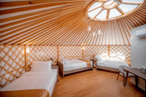 a yurt with two beds and a large window at Juulchin Terelj Resort in Ulaanbaatar