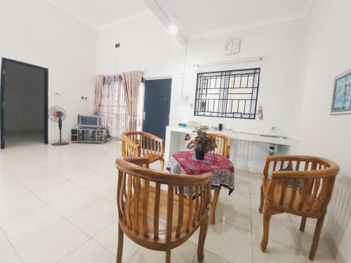a dining room with a table and four chairs at Rumah Lavender near OPI Mall Jakabaring in Palembang