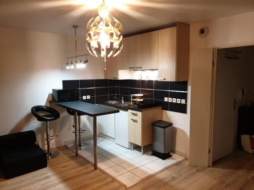 a small kitchen with a table and a chandelier at Studio proche rer e in Rosny-sous-Bois